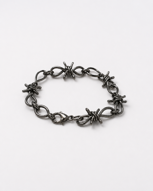 Barbed wire charms unisex bracelet - metallic grey grunge wrist cuff on a white table