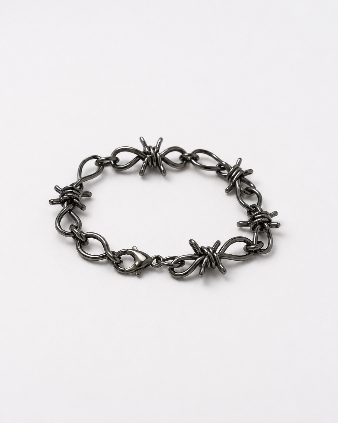 Barbed wire charms unisex bracelet - metallic grey grunge wrist cuff on a white table 